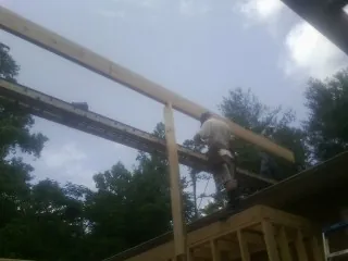 Carpenter setting a ridge beam over a new addition frame — Ice Dam Removal by Roofing Brothers in Platteville