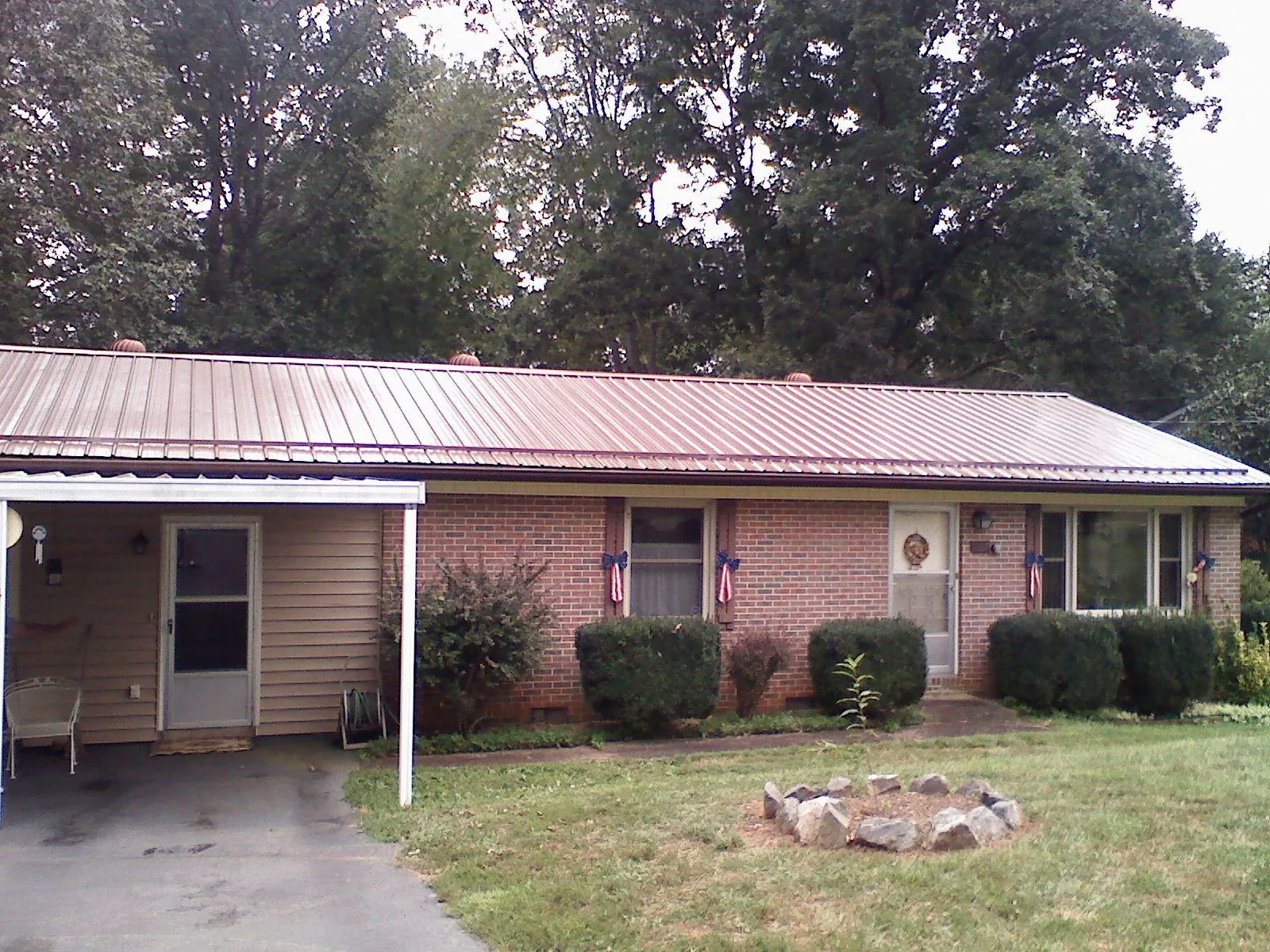 Bronze metal roof and carport on a brick ranch home — Roof Repair work by our crew in Platteville