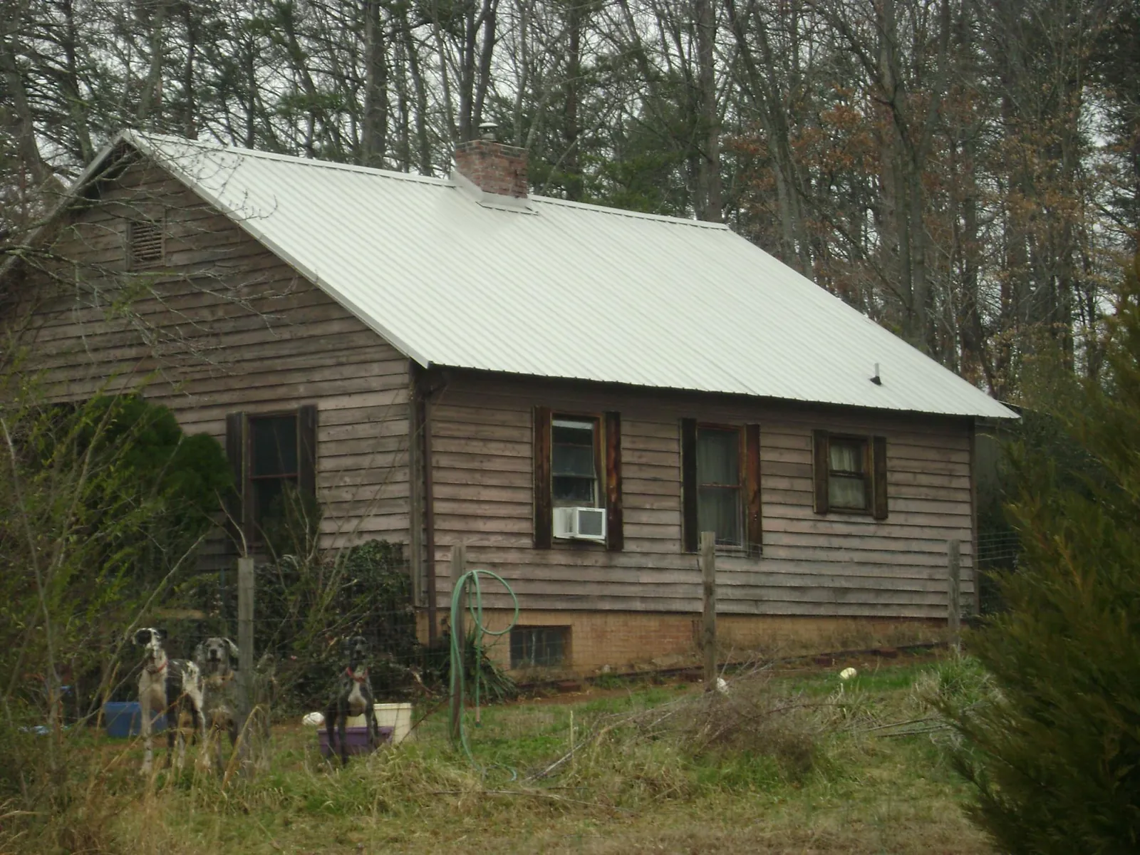 White metal roof on an old wood sided farmhouse, from a Metal Roof Installation job in Platteville